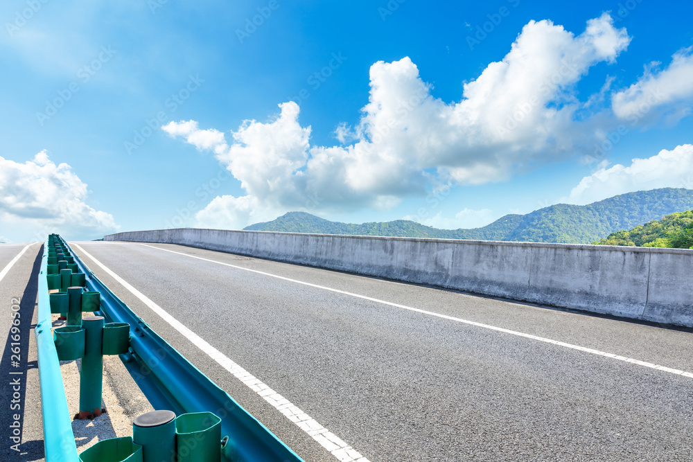 Empty asphalt road and mountains with blue sky on a sunny day