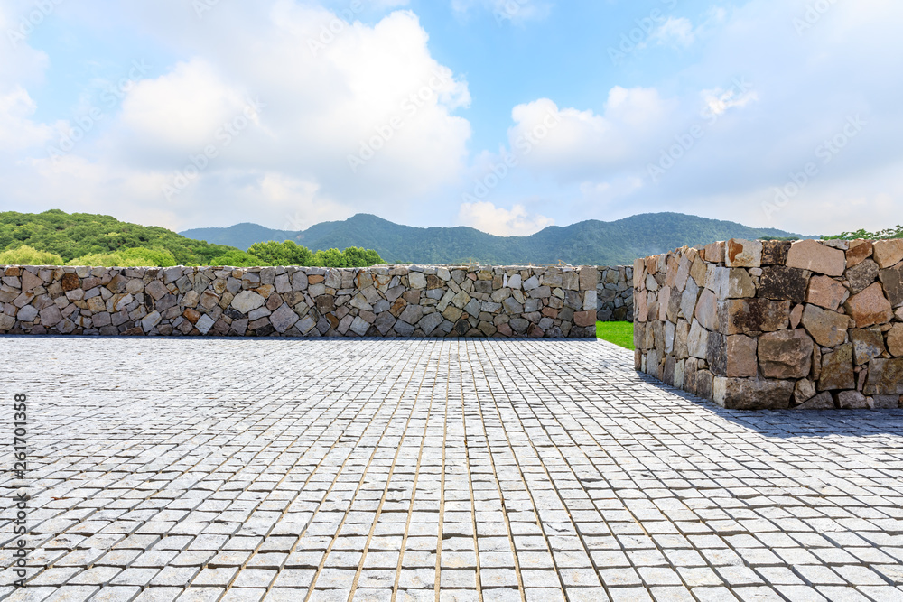 Rough square stone floor and green mountain with sky landscape