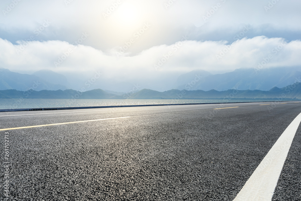 空旷的柏油路和有山地景观的河流