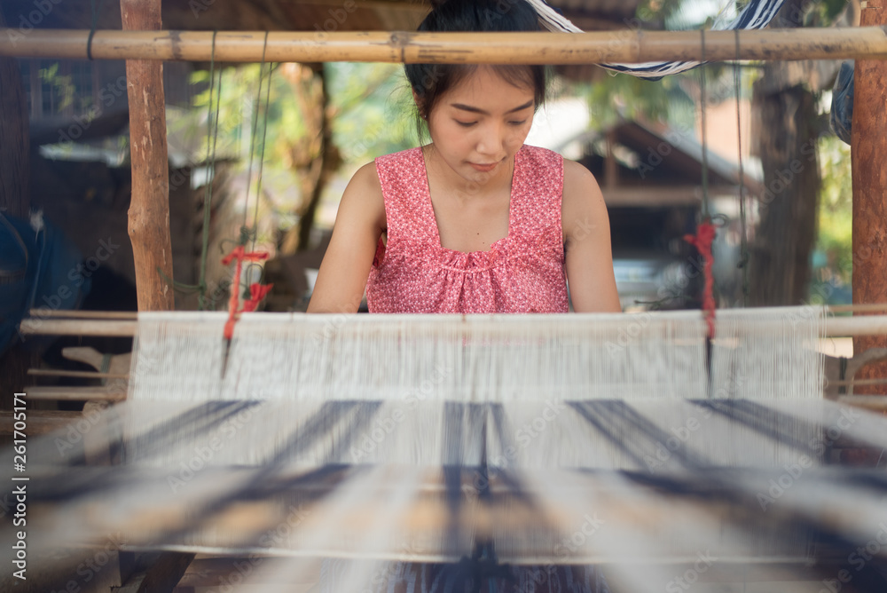 Young women weaving with traditional Thai weaving machine