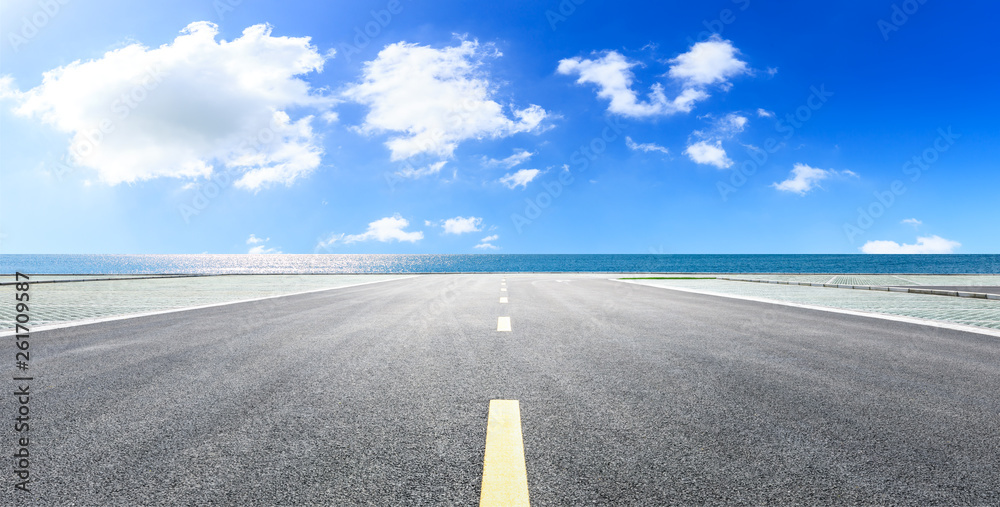 空旷的柏油路和蓝天背景的大海