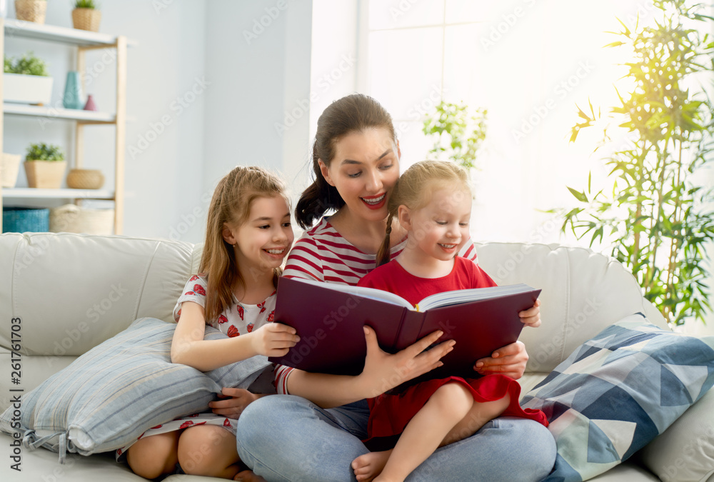 mother reading a book to daughters