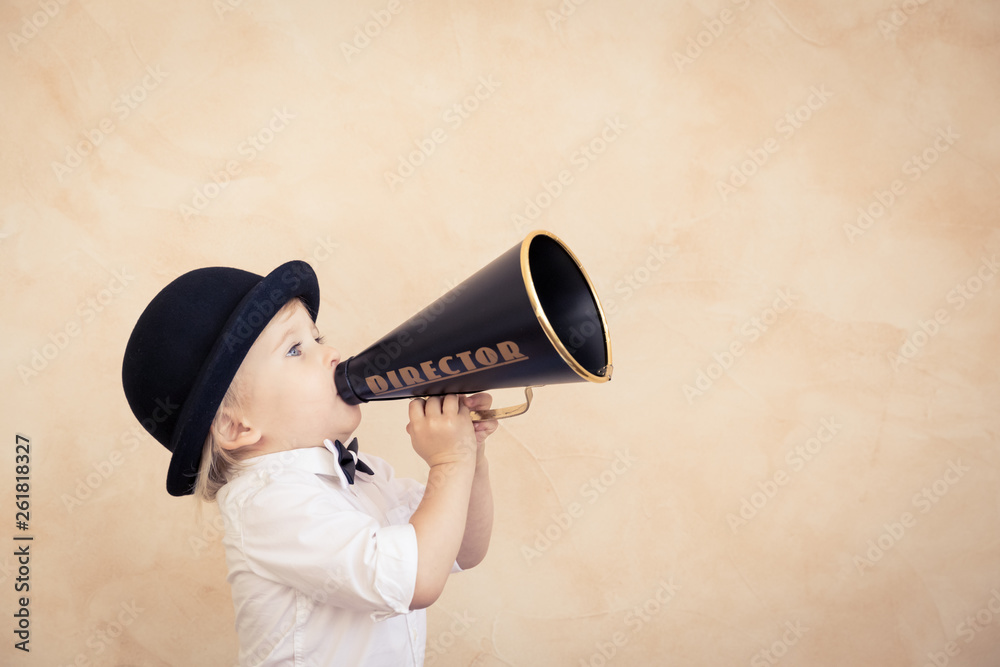 Funny child playing with black retro megaphone