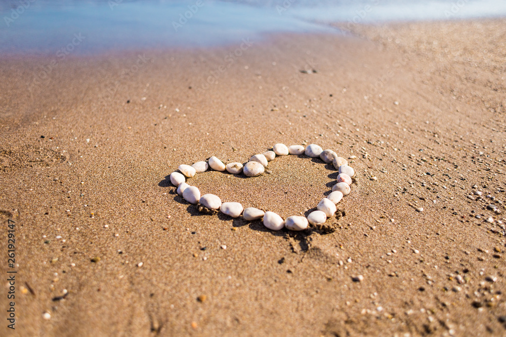 Heart of pebbles on the sand.