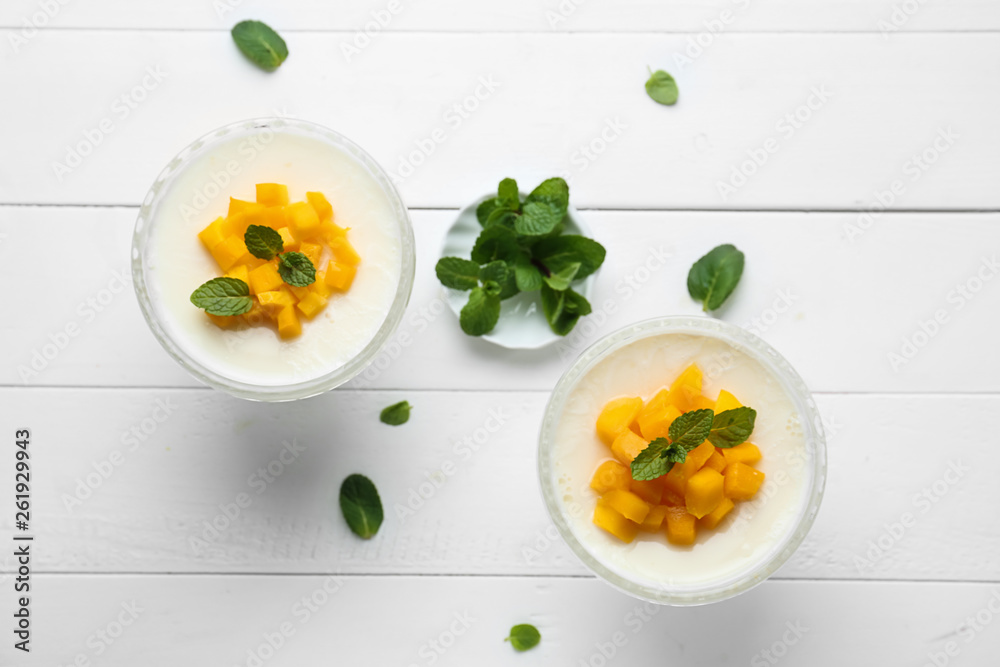 Bowls of delicious panna cotta on white table