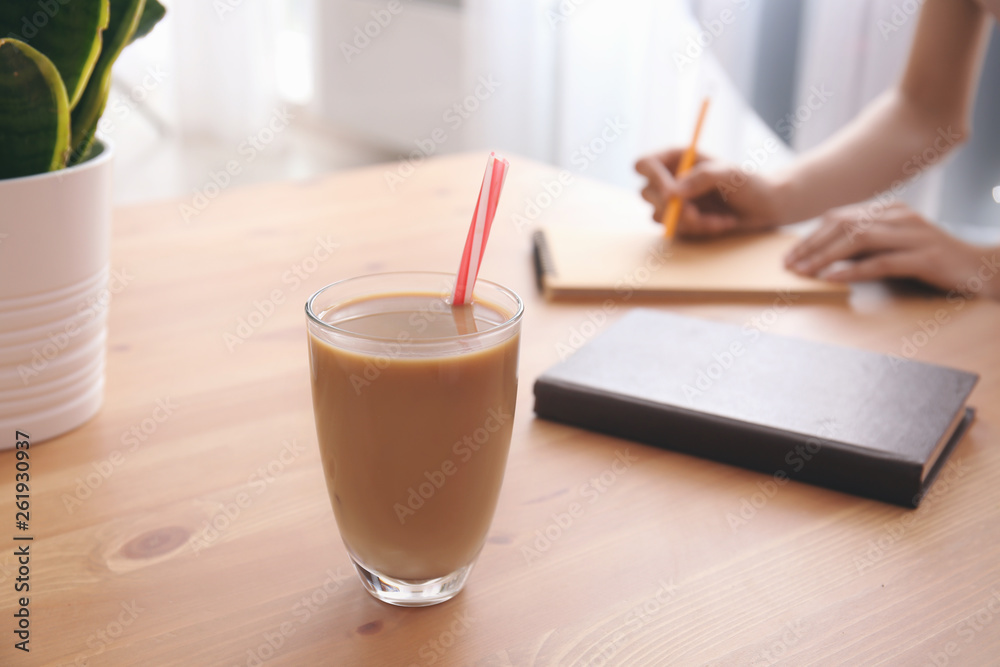 年轻女士桌上的一杯美味的frappe咖啡