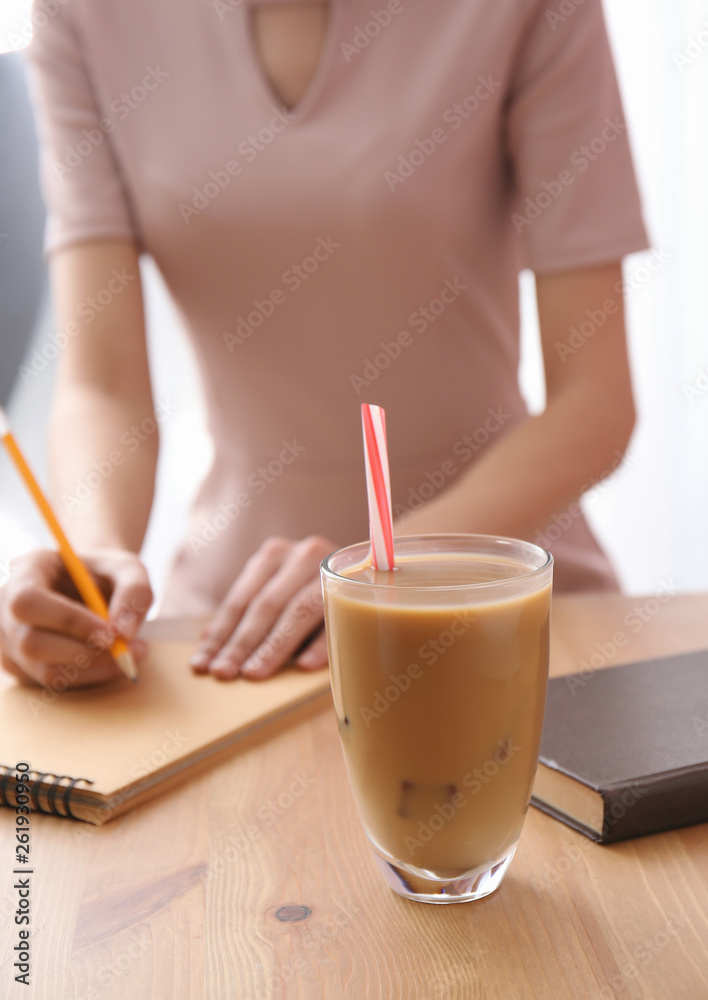 年轻女士桌上的一杯美味的frappe咖啡