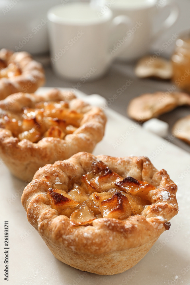 Tasty apple pies on white board, closeup