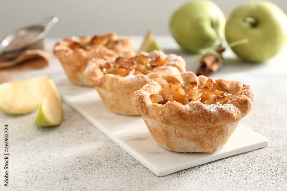 Tasty apple pies on grey table