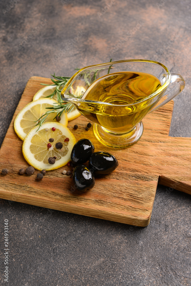 Gravy boat with tasty olive oil on grey table