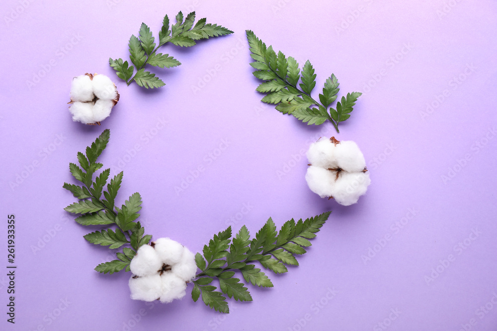 Frame made of cotton flowers with leaves on color background