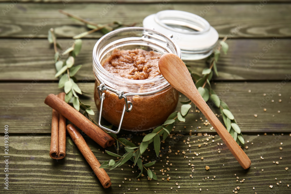 Jar with sugar scrub on wooden table