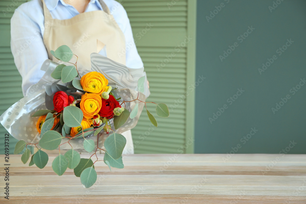 花艺师在餐桌上捧着美丽的花束