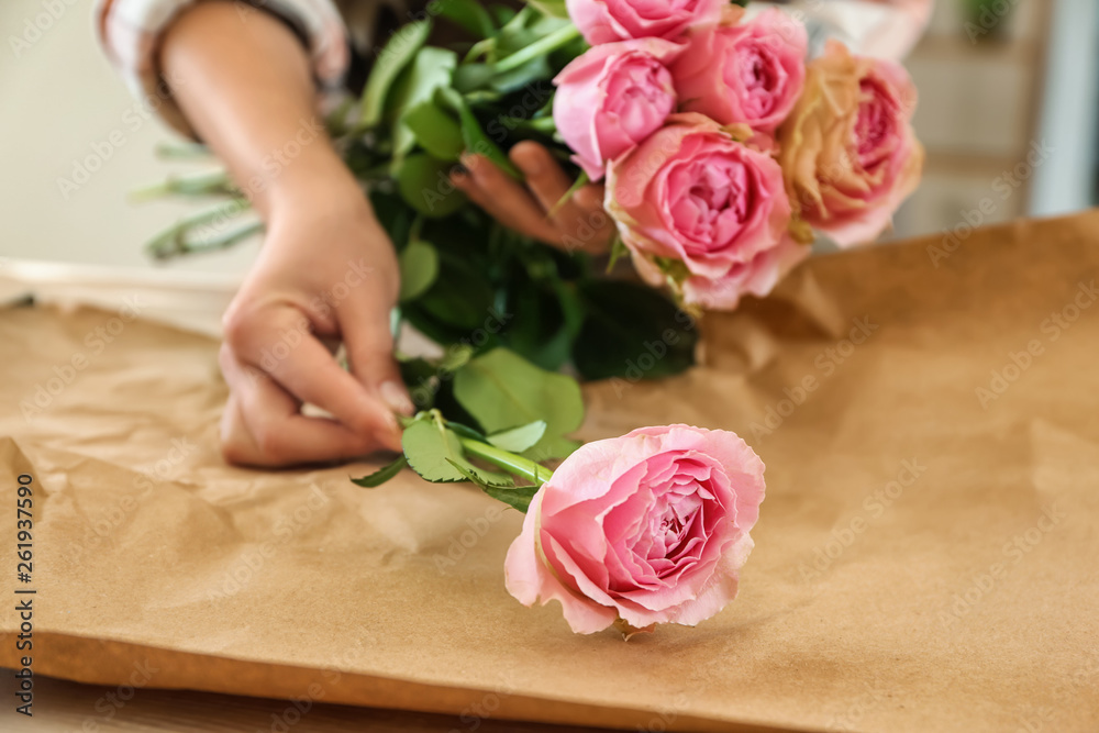 Florist making beautiful bouquet at table, closeup