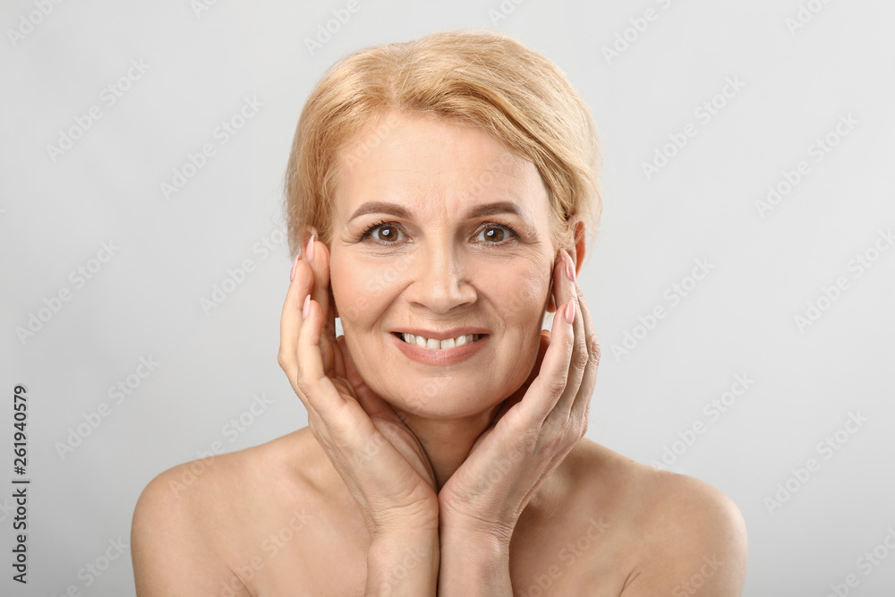 Portrait of beautiful mature woman on light background