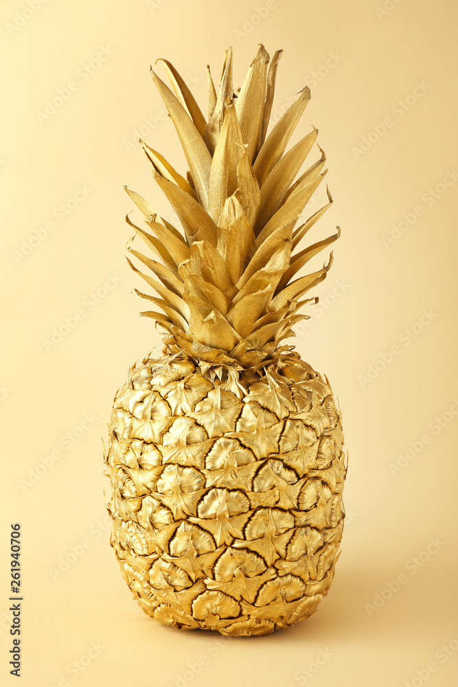 Golden pineapple on color background