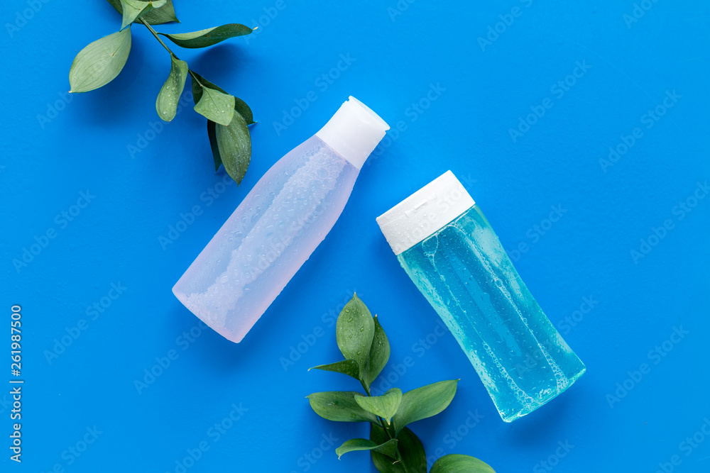 Organic cosmetics for face clearing with facial tonic and mycelial water on blue background top view