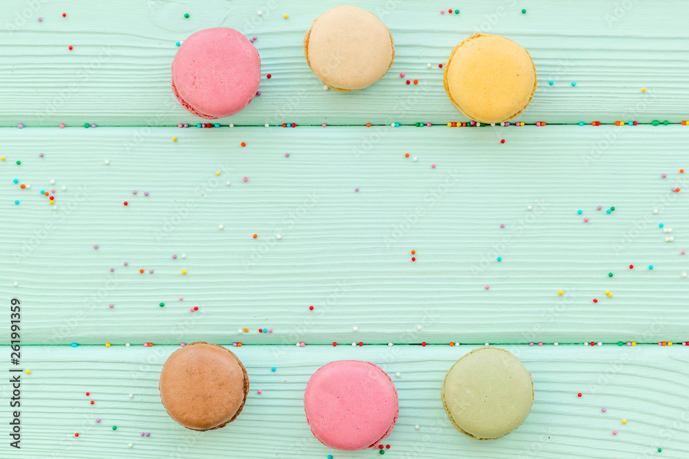 sweet dessert pattern with macarons on mint green wooden background flat lay mockup