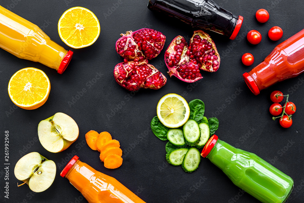 bottles with fresh carrot, tomato, apple, cucumber, lemon, pomegranate juices on black background to