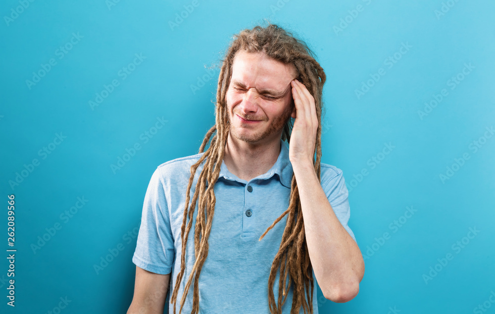 Young man feeling stressed on a solid background