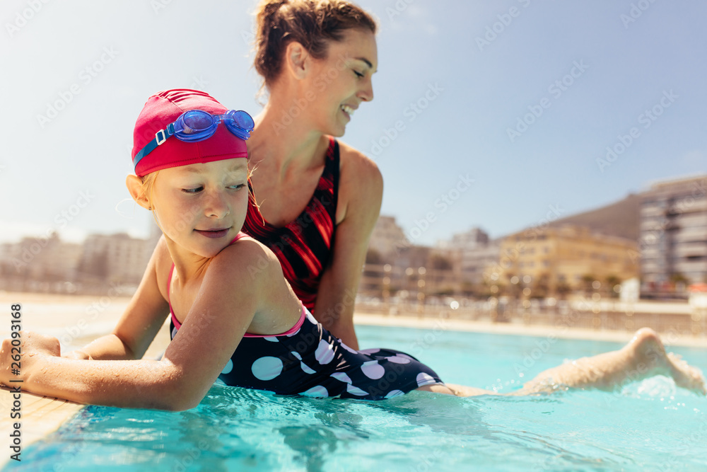 Mother teaching her daughter to swim