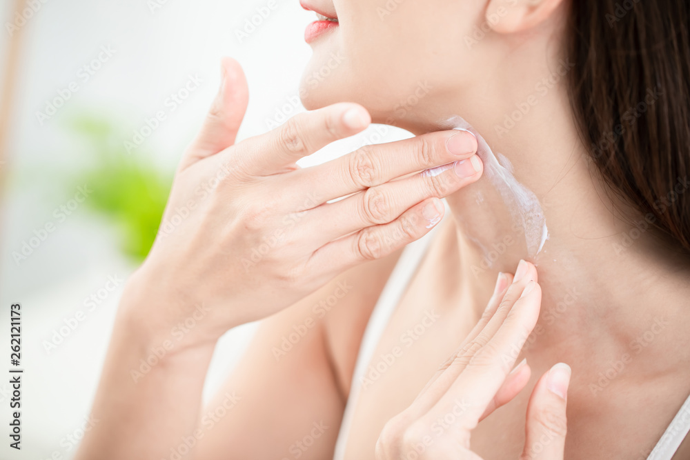 woman applying cream on neck