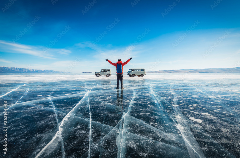 Traveler man wear red clothes and raising arm standing on natural breaking ice in frozen water at La