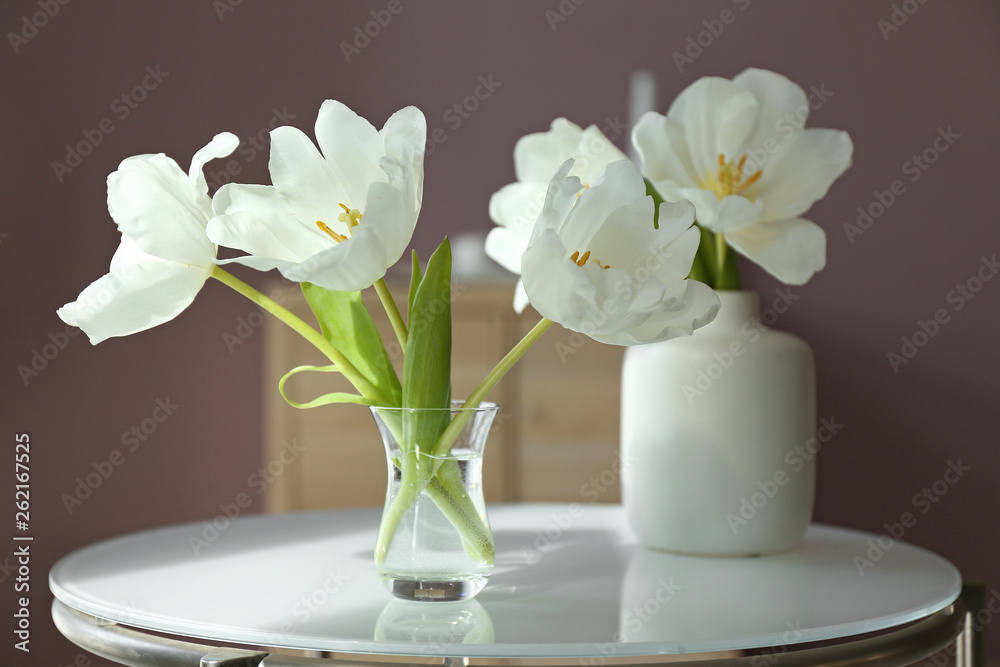 Beautiful flowers on glass table in room