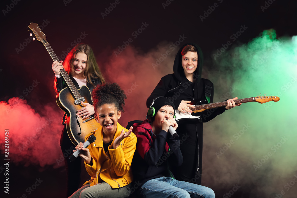 Band of teenage musicians on dark background