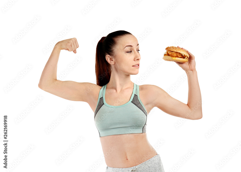 Sporty woman with burger on white background