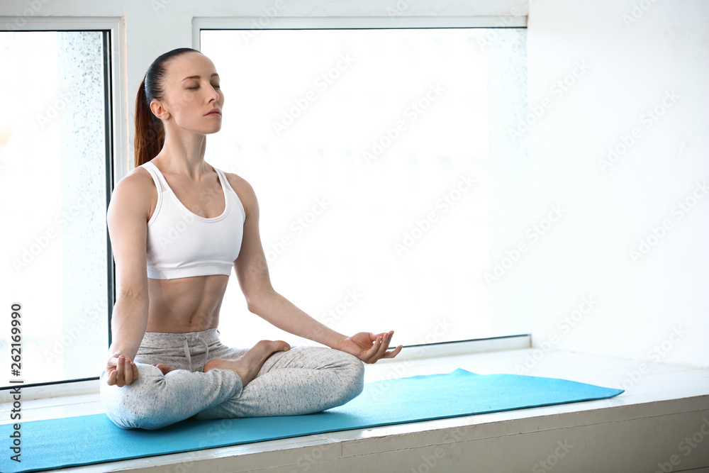 Sporty woman practicing yoga in gym