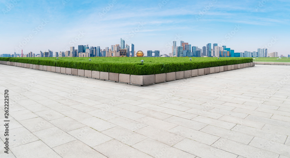 Empty square tiles and skyline of urban buildings..