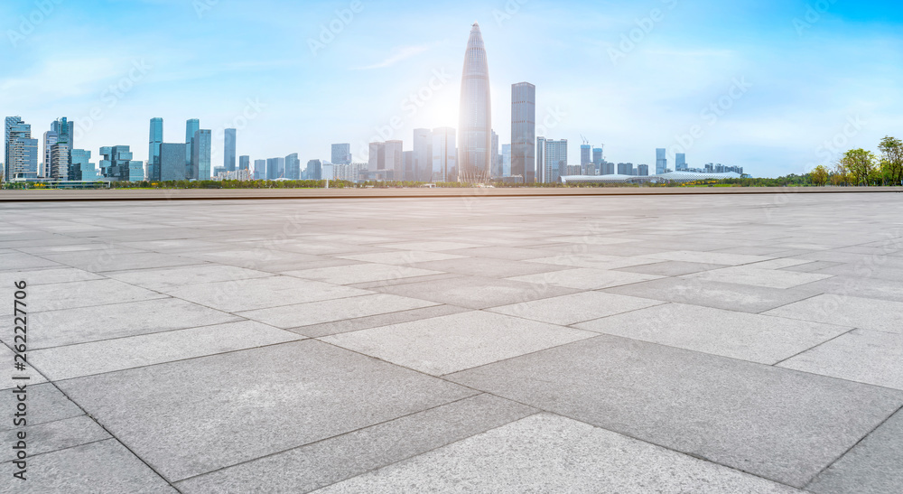 Empty square tiles and skyline of urban buildings