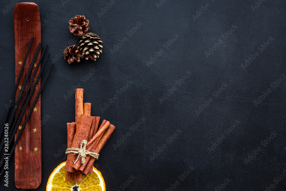 incense sticks with citrus and cinnamon for fresh air on dark background top view mock up