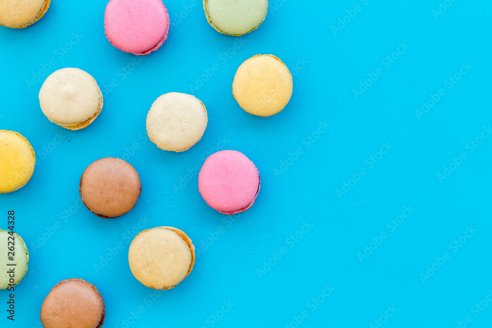 Macarons dessert pattern on blue background top view copy space