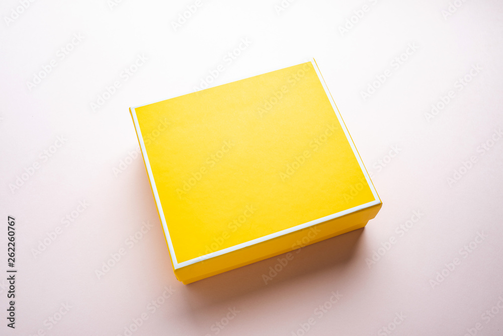 a yellow gift box on a pink background