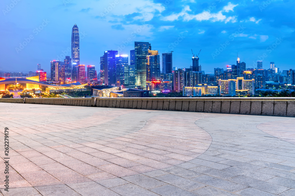 Empty square tiles and skyline of urban buildings