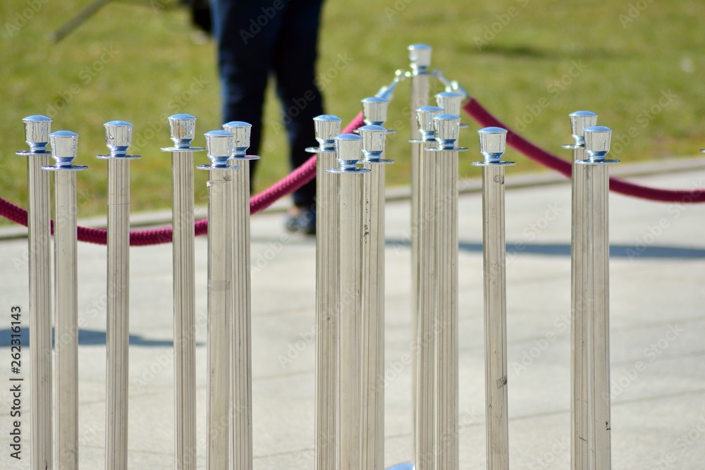 Silver stanchions with a purple rope.