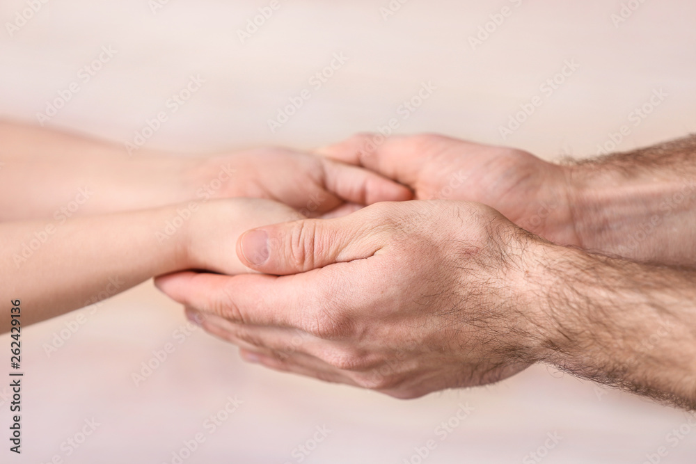 Hands of man and child on blurred background