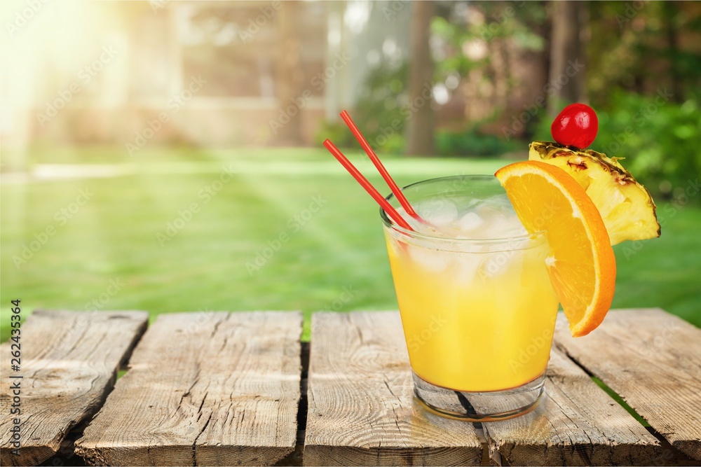 Glass of delicious orange juice on natural background