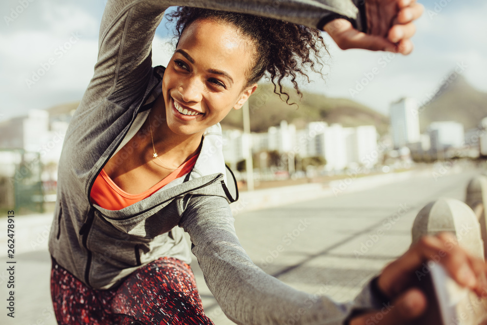 Athletic woman stretches outdoors