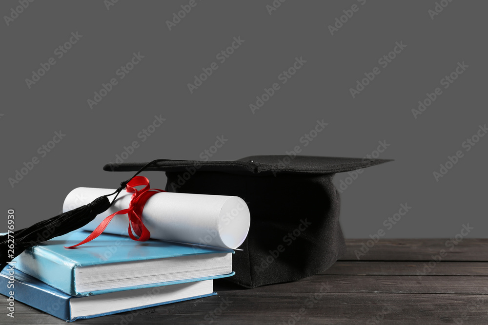 Mortar board, diploma and books on table. Concept of high school graduation