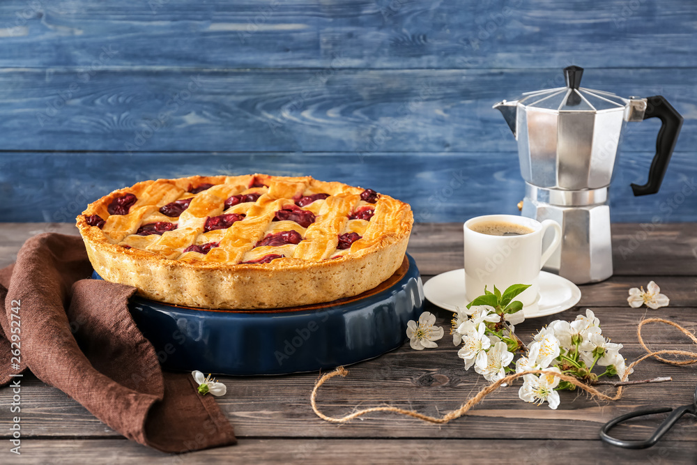 Composition with tasty cherry pie and cup of coffee on wooden table