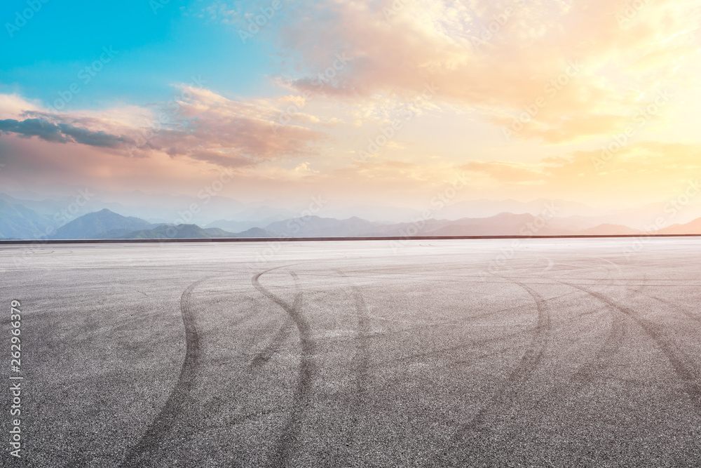 Asphalt race track ground and mountain with sunset clouds