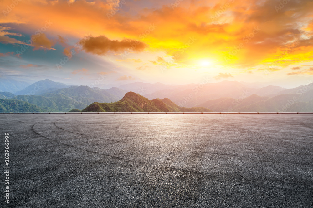 Asphalt race track ground and mountain with sunset clouds