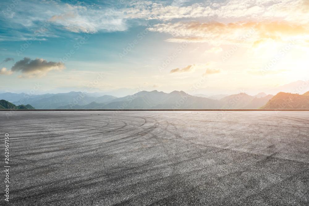 Asphalt race track ground and mountain with sunset clouds