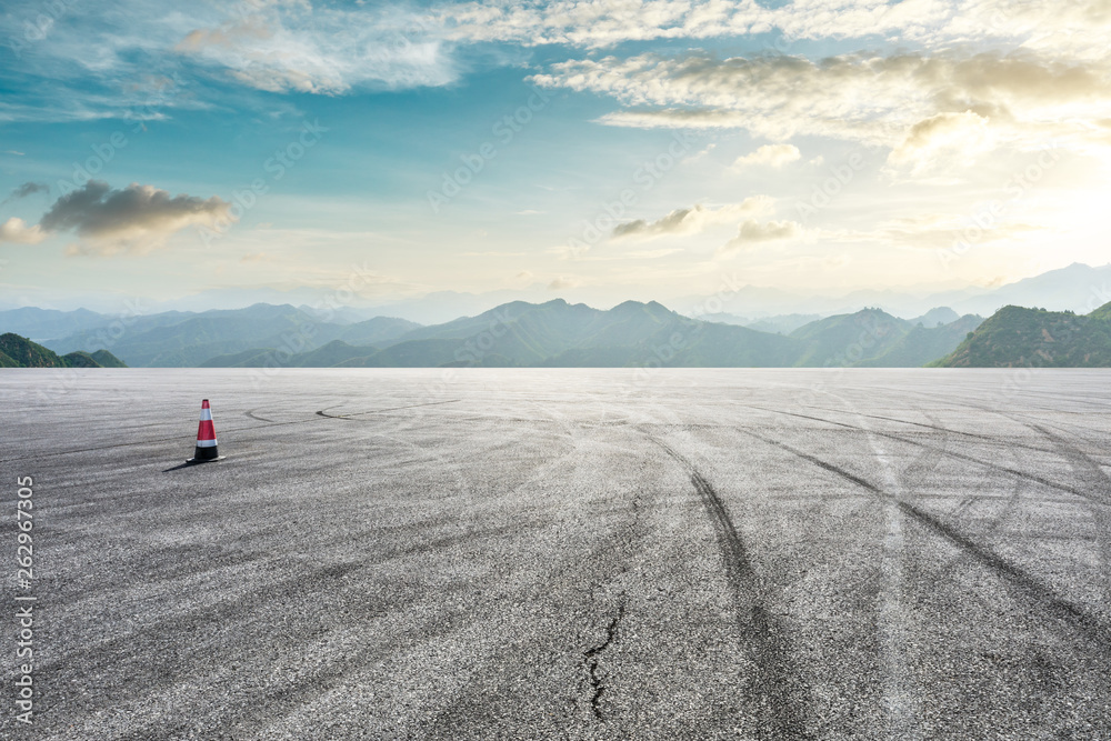 Asphalt race track ground and mountain with sunset clouds