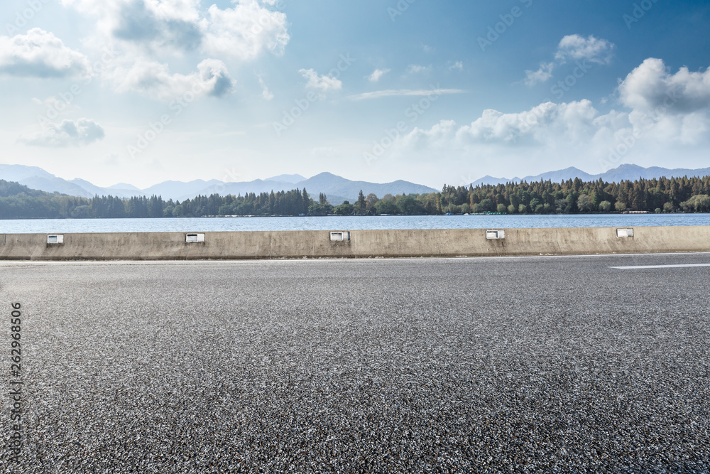 Empty asphalt road and mountains with lake landscape