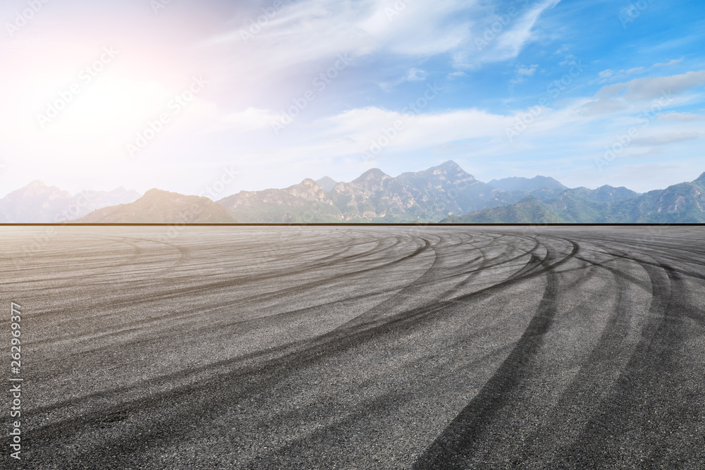 Asphalt race track ground and mountain with clouds background