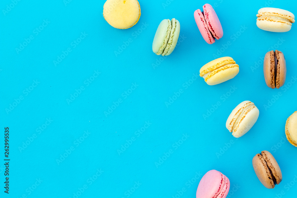 Macarons dessert pattern on blue background top view copy space